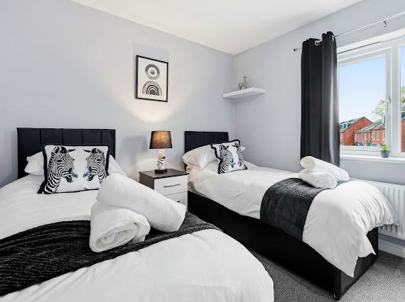 Monochrome twin bedroom styled with zebra print cushions